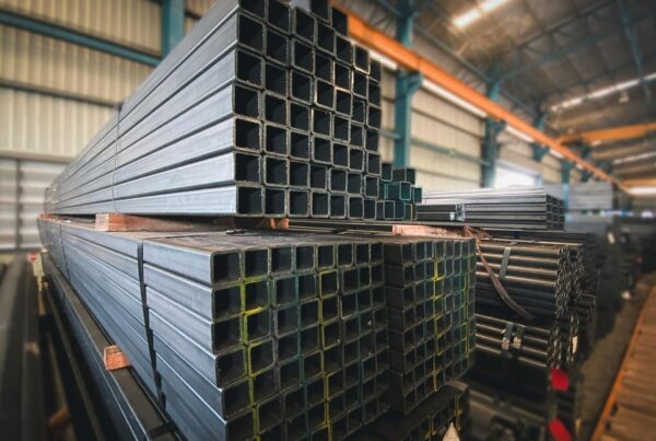 A neatly arranged stack of flat steel pipe, varying in size, placed in an industrial warehouse. The pipe displays clean, uniform cuts and smooth surfaces, emphasizing their precision and quality for different applications.